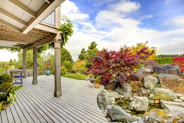 Deck with balcony and view of the backyard garden.