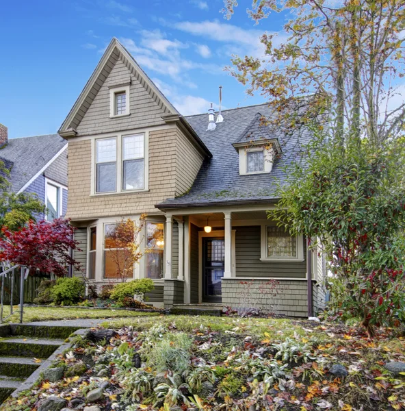 American Northwest home with front porch with railing and autumn landscape