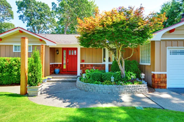 Cute small rambler house with red door and white trim.