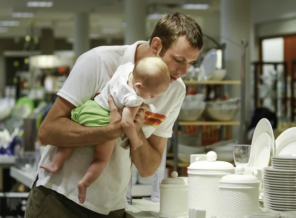 Family shopping. Young father and his daughter in the mall. He shows something