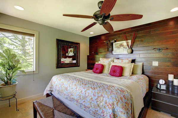 Elegant luxury master bedroom with wooden accent wall.