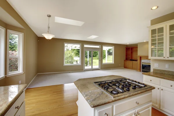 Empty house interior with open floor plan. Living room with view of the kitchen area.