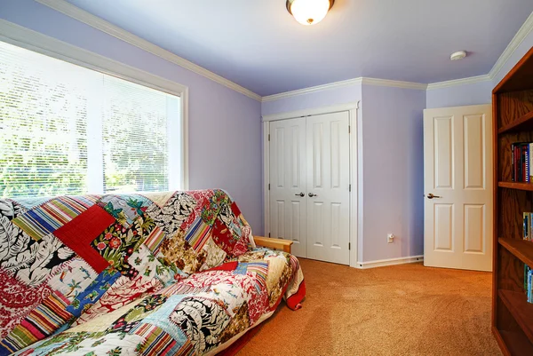 Small living room interior with light purple walls and carpet floor.