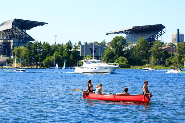 Seattle, WA - March 23, 2011: Children on the boat, Husky Stadium at the background
