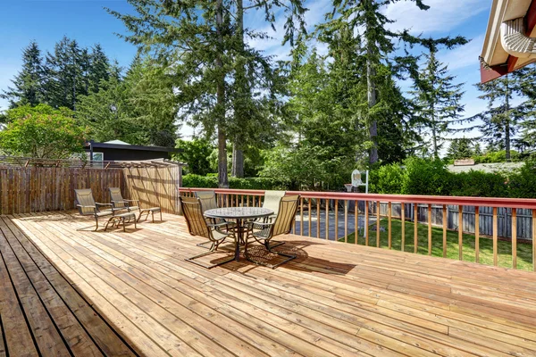 Spacious wooden deck with patio table set.