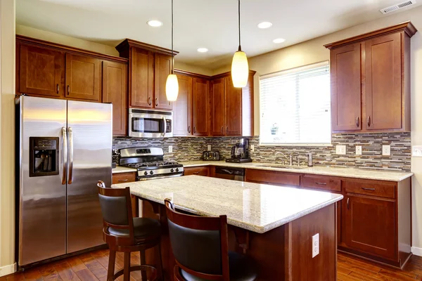 Kitchen mahogany storage combination with steel kitchen appliances and back splash trim