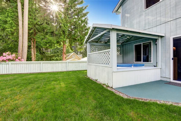 Outdoor covered hot tub in the backyard garden.