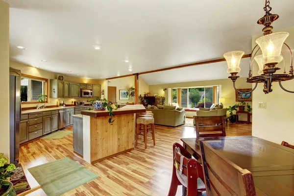 Home interior with hardwood floors and open floor plan showing dining room, kitchen, and living room.