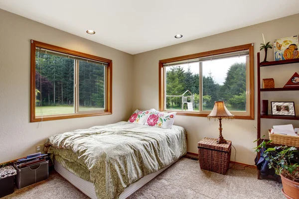Nice bedroom interior  with carpet floor and two windows.