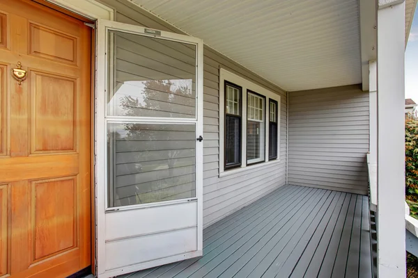 Empty covered porch with double front door.