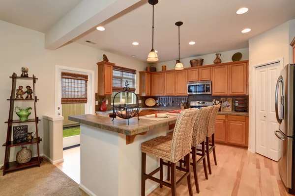 View of kitchen with hardwood storage combination, bar and pendant lights