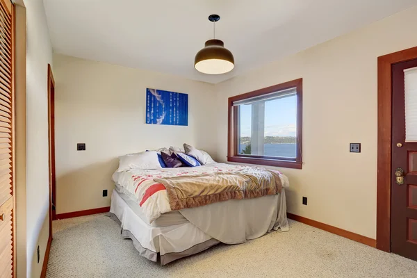 Simple bedroom with one bed, carpet floor and white walls