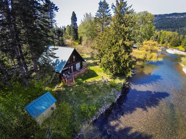 Panoramic view of cabin style home on a river bank