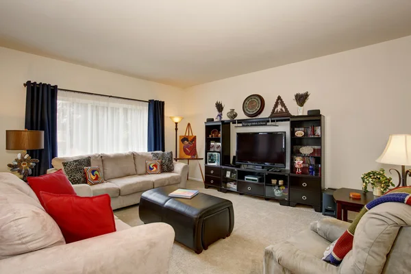 Cozy living room with beige sofa set and black furniture set.