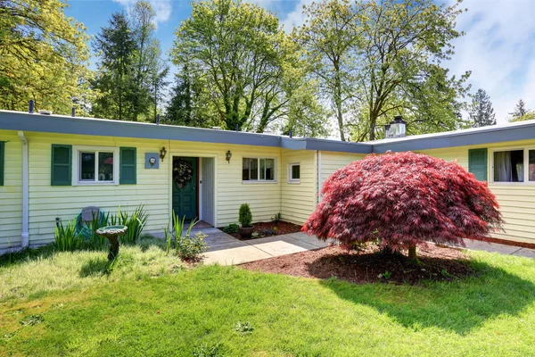 Exterior of American rambler house with grass filled front garden