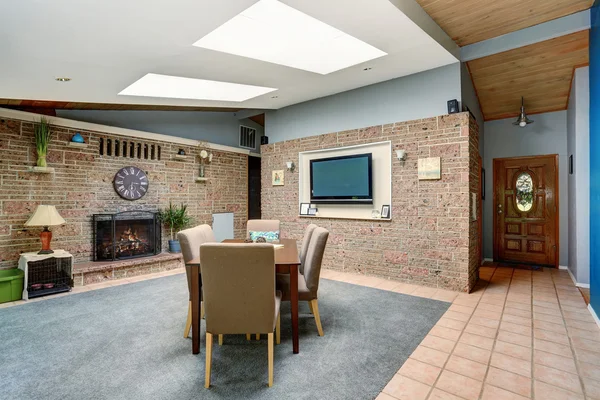 Light spacious dining room with stone tile wall and built-in fireplace