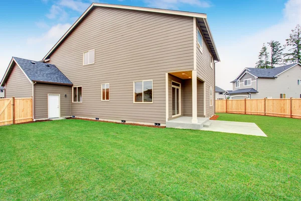 Fenced back yard exterior with well kept lawn