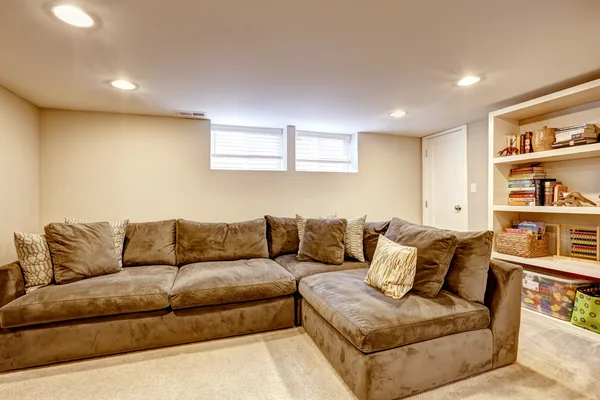 Spacious family room with large corner sofa and bookcase.