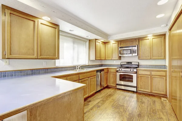 Kitchen with golden wood cabinets and hardwood floor.
