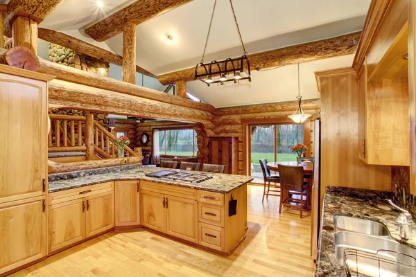 Log cabin kitchen interior design with honey color cabinets.