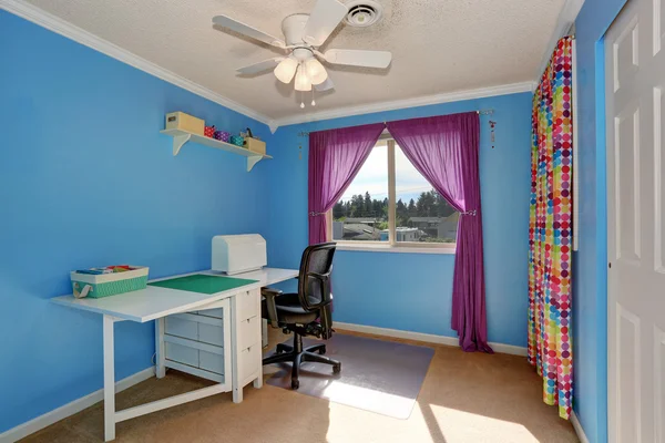 Bright blue sewing room interior with colorful curtains.