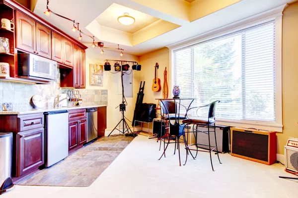 View of kitchen interior in misician\'s home with small rehearsal area.
