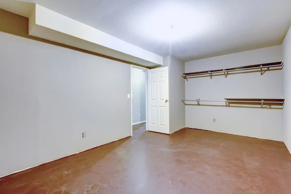 Spacious empty garage interior with two shelves on the wall.