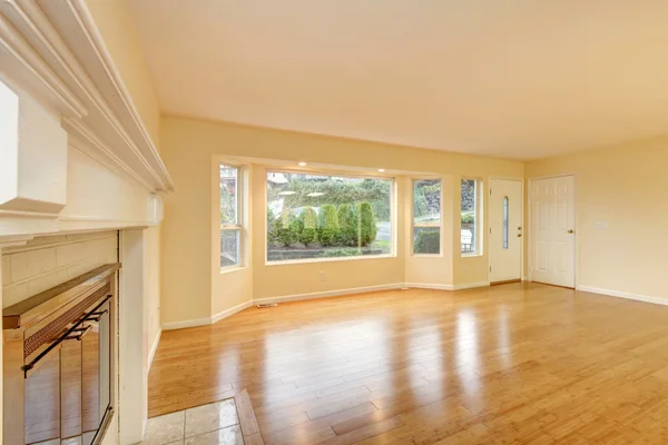 Empty living room interior with polished hardwood floor.