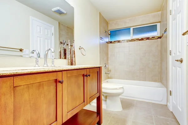 White bathroom interior with tile wall  trim and tile flooring.