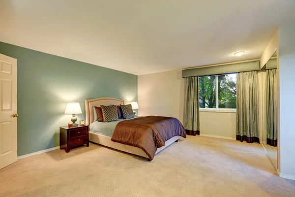 Mint and brown bedroom with beige carpet floor.