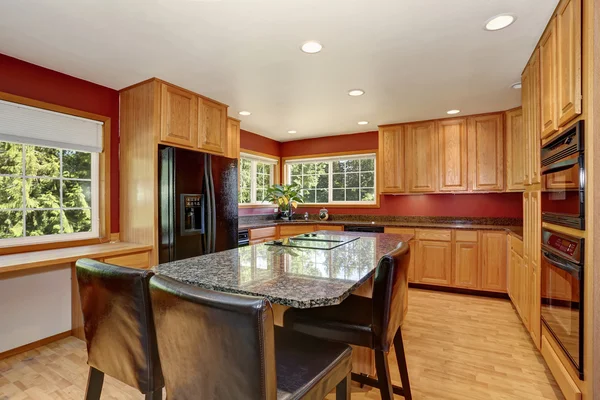 Kitchen room interior with red walls, granite counter top and bar stand.