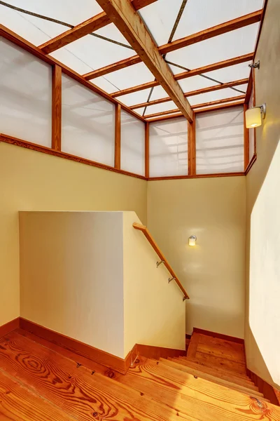 Hallway interior with wooden trim and hardwood floor. View of stairs.