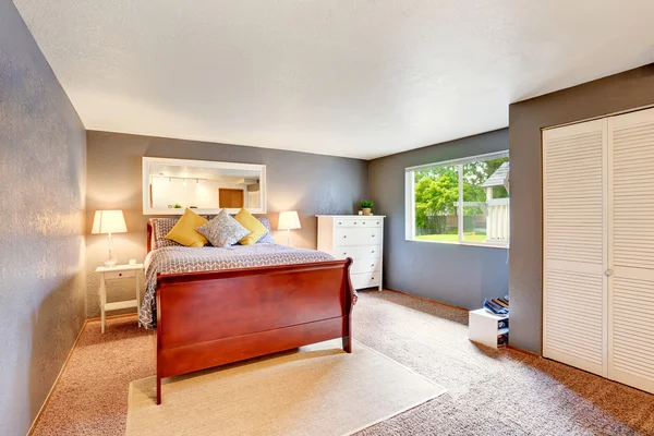 Bedroom interior with blue walls, carpet floor and white wardrobe.