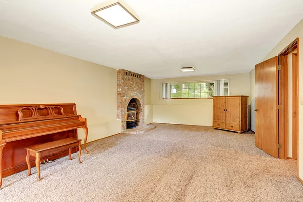 Empty living room interior with fireplace, carpet floor and antique piano