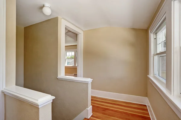 Hallway interior with beige walls and hardwood floor.