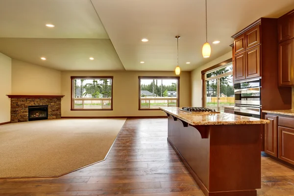 Empty living room with fireplace. Connected to kitchen area.