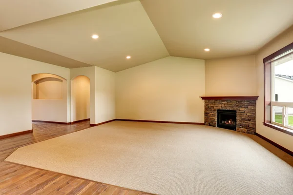 Empty living room with fireplace. Connected to kitchen area.