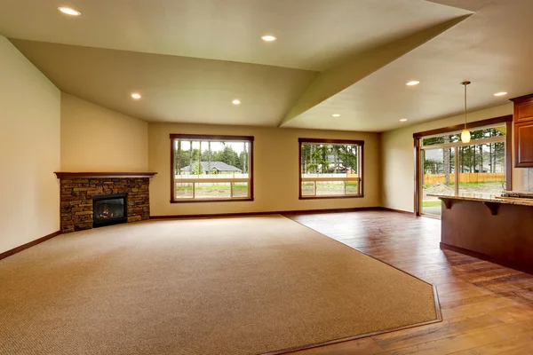 Empty living room with fireplace. Connected to kitchen area.