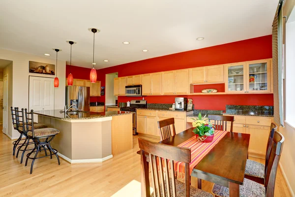 Kitchen room interior with red wall, granite counter top and island.