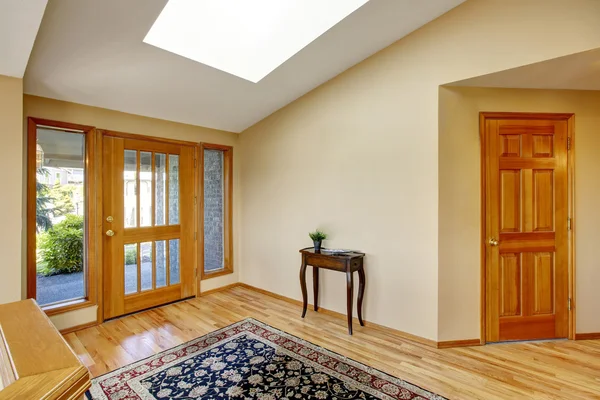 Nice bright entry way to home with hardwood floor and rug.