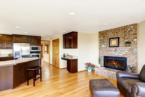 Open floor plan kitchen and living room with brick fireplace.