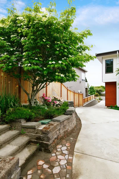 Fenced backyard with concrete driveway to garage.