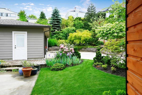 Nice back yard landscape desing with well kept lawn.