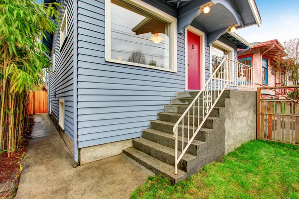 Classic American house exterior with blue trim and red front door