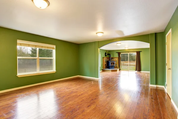 Open floor plan interior with green walls and hardwood floor.