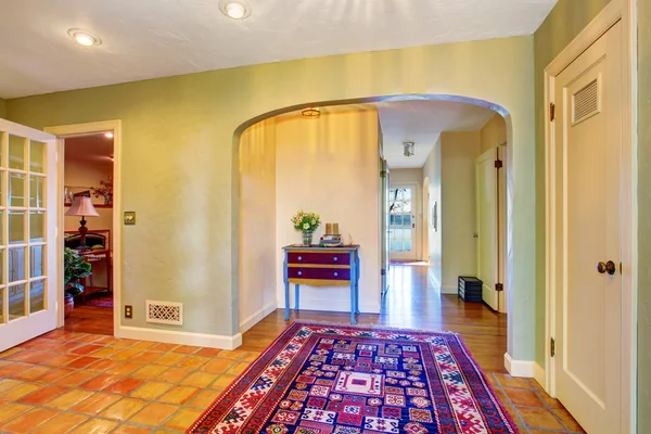 Empty hallway interior with green walls and rug