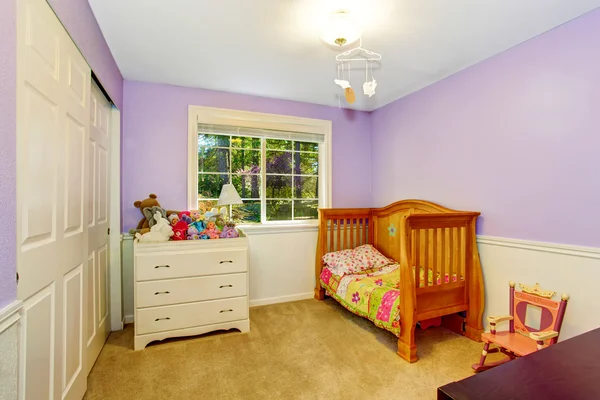 Kids bedroom interior in purple tones with lots of toys