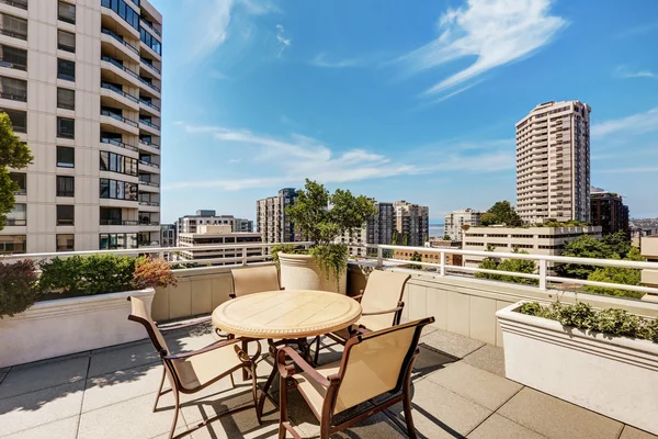 Apartment building roof top terrace exterior with patio table set
