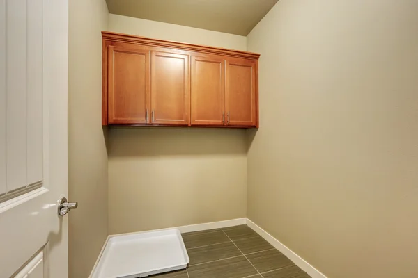 Empty beige laundry room with tile floor.