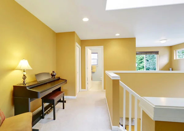 Bright hallway interior with yellow walls and piano